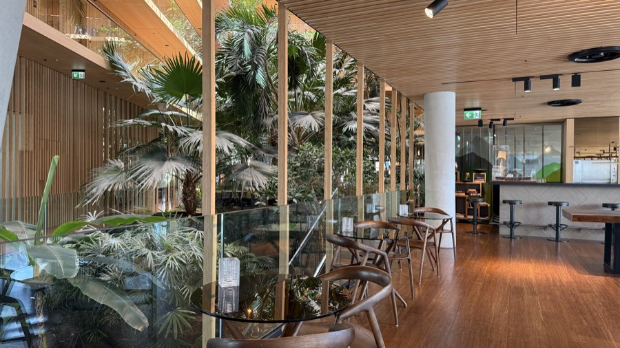 Restaurant seating beside the glass wall of the garden